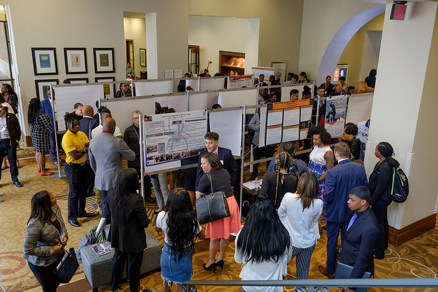 The crowd gathers in the lobby to network and peruse new research at the poster session 