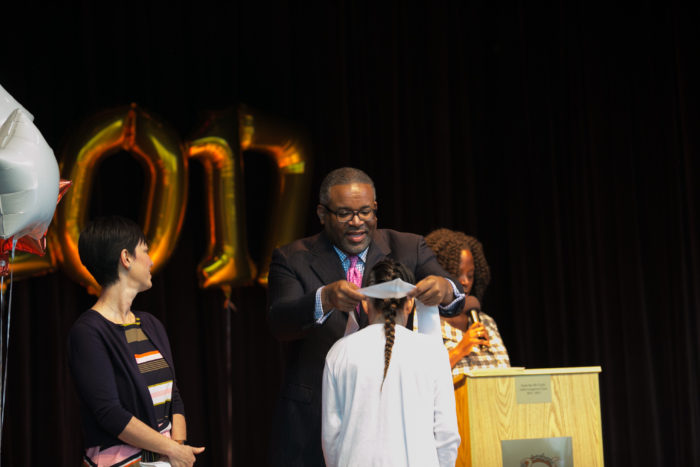 Dr. Vincent awarding the graduate sash
