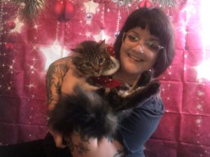 Katie with her cat in festive Christmas attire