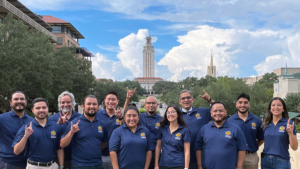 PM staff raising the hookem horns with the UT tower in the background