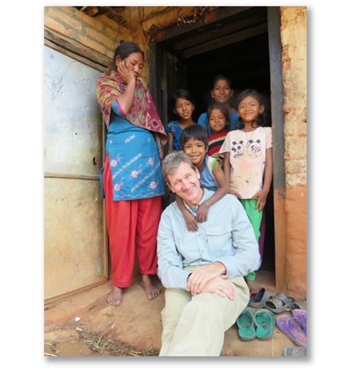 Dr. Tinker visiting with a family outside their home in Nepal 