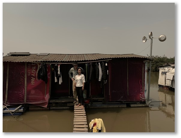 A woman in Vietnam standing outside her floating house 